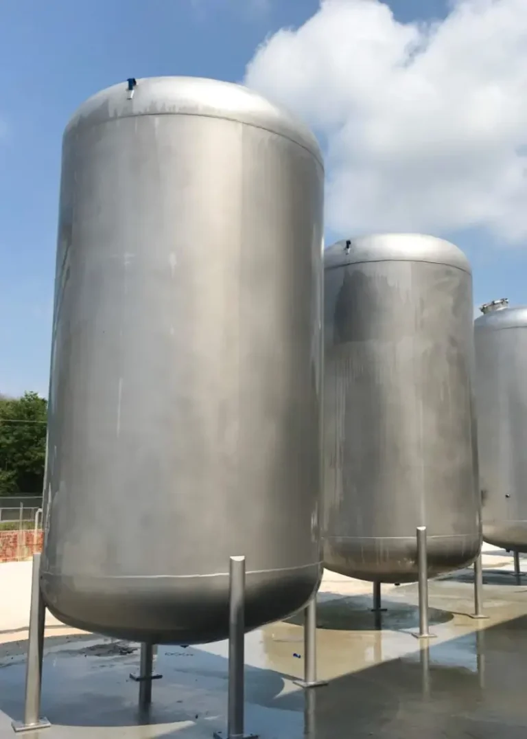 Three stainless steel activated carbon towers on legs installed outdoors