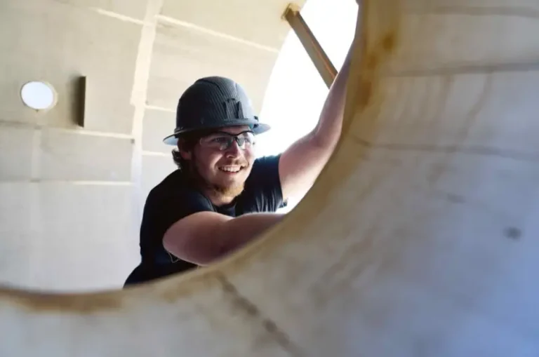 Watson field service technician in hard hat and safety glasses repairing an industrial tank