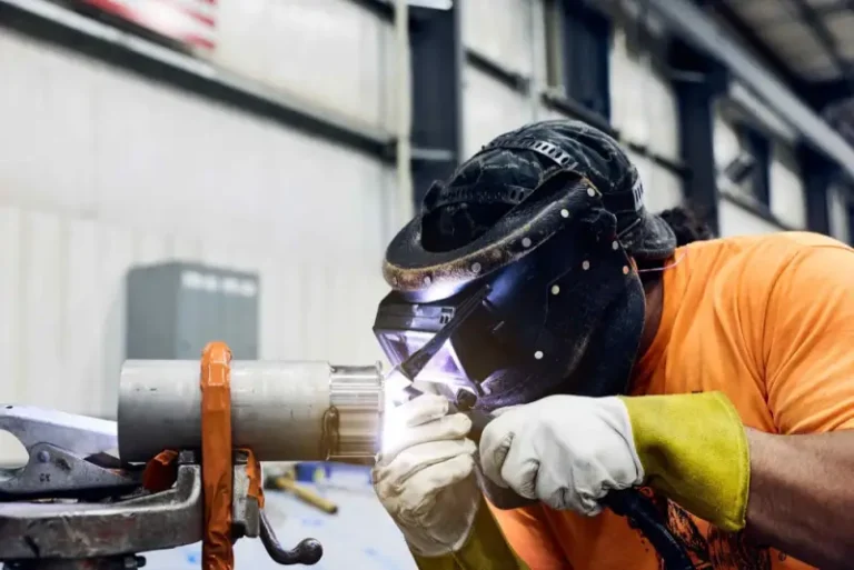 Watson welder in protective gear welding a stainless steel pipe for a replacement tank part